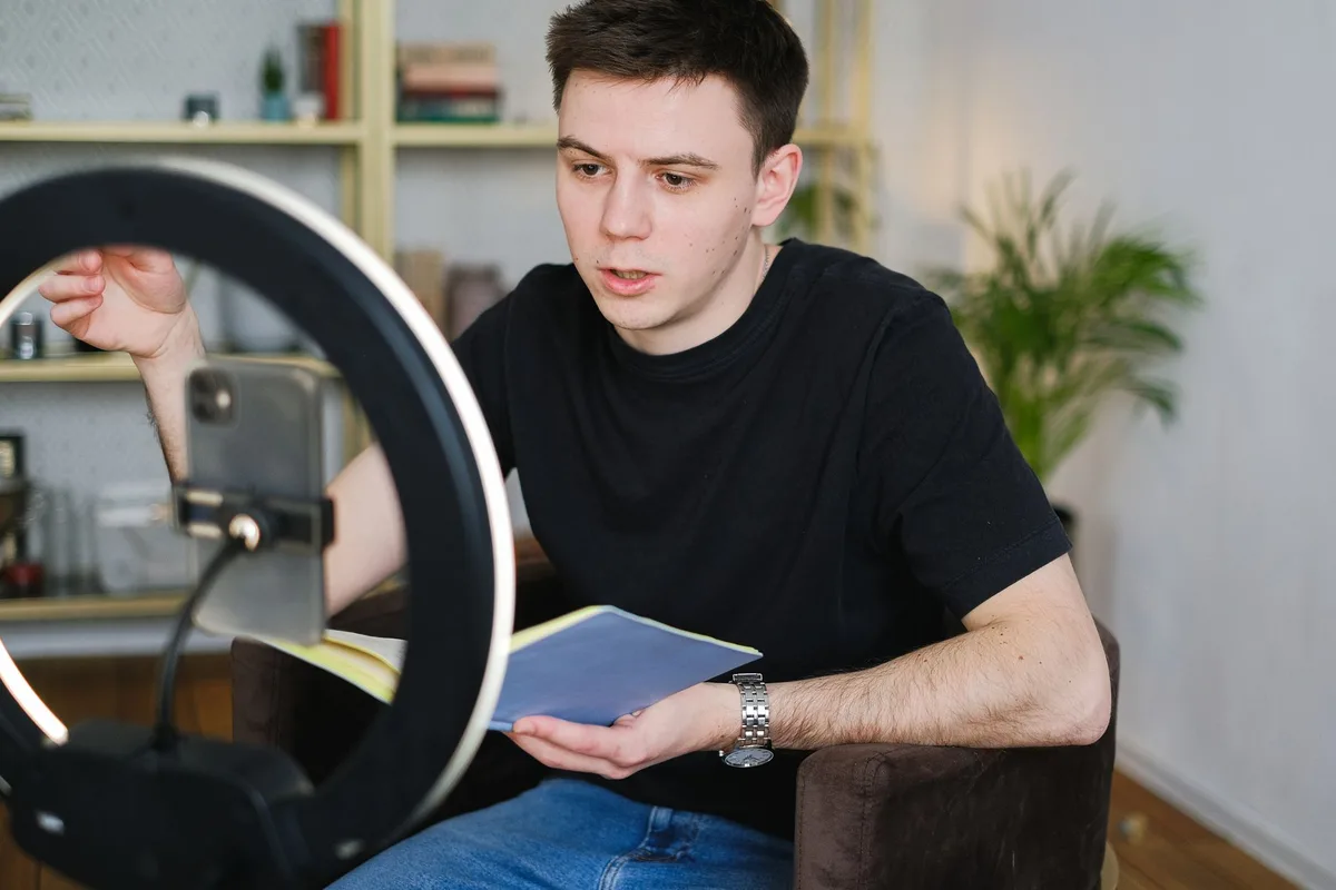 Creator filming a TikTok Duet response video on a smartphone with a ring light in a well-lit room
