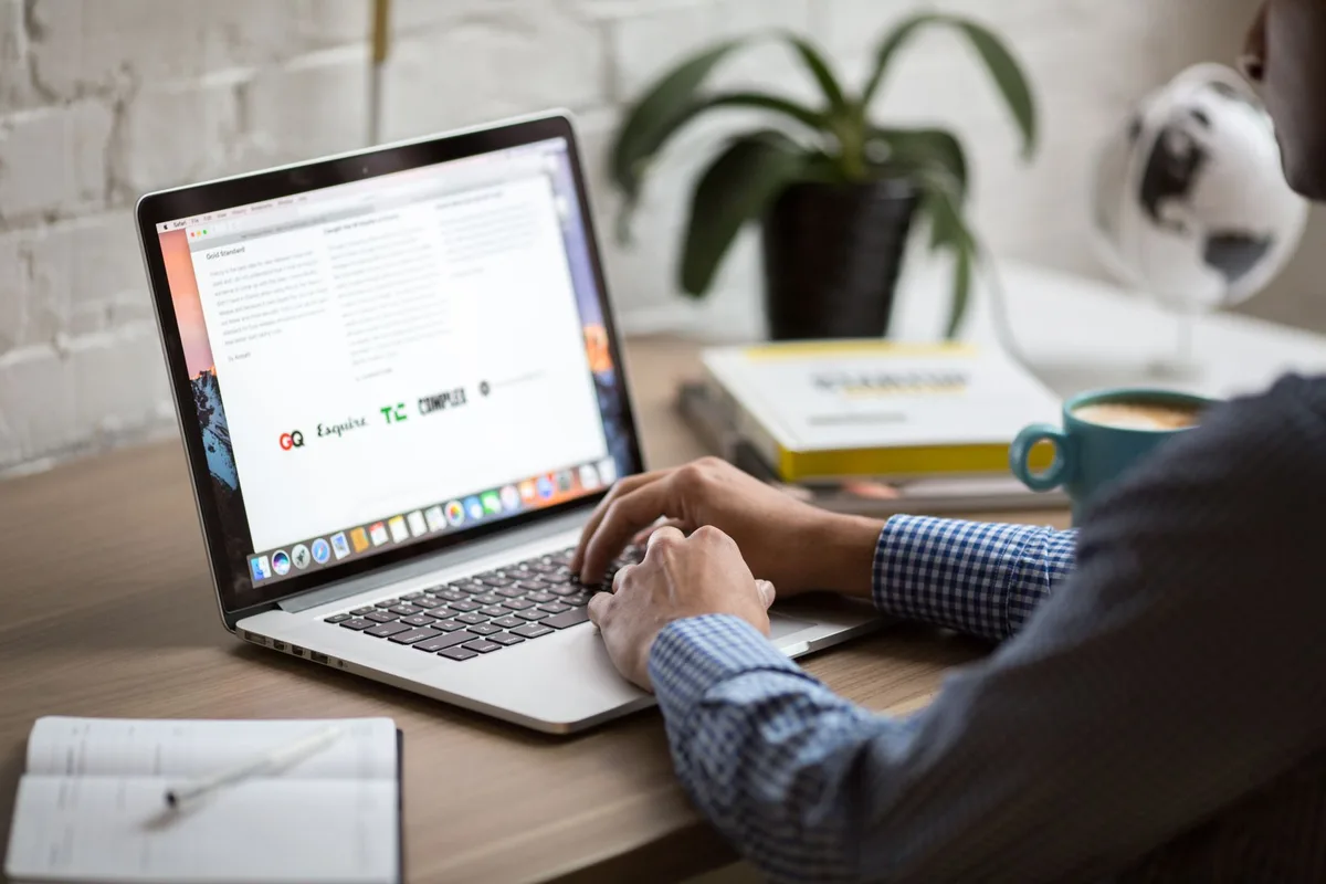 Creator writing a newsletter on a laptop at their desk