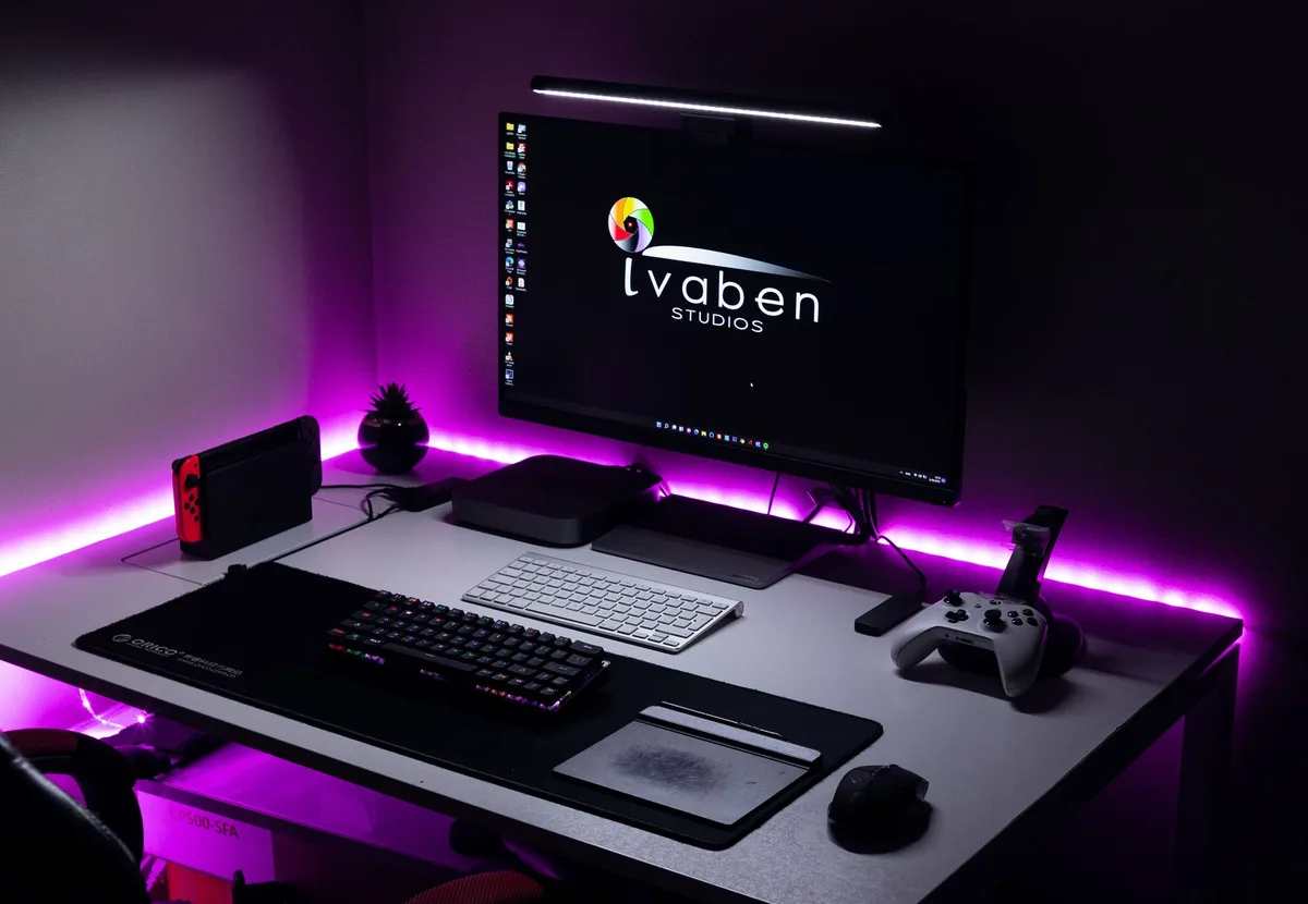 A modern workspace featuring dual computer monitors displaying web design projects